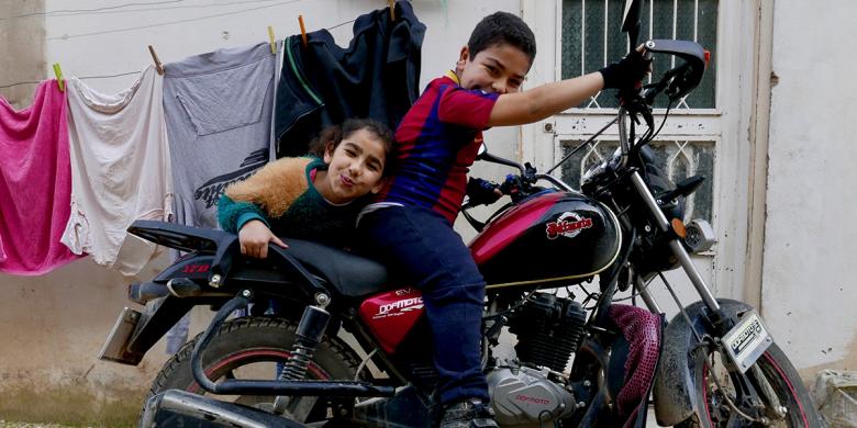 Photo: two children from sitting on a motor bike